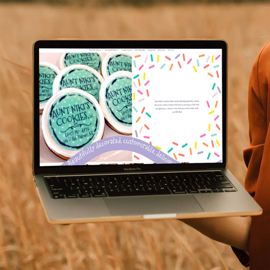 Woman holding an open laptop to the side with the homepage of Aunt Niki's Cookies on the screen.