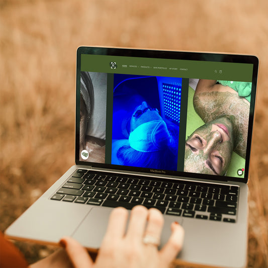 Woman holding a laptop open with a page of Renewal Room's website on the screen.