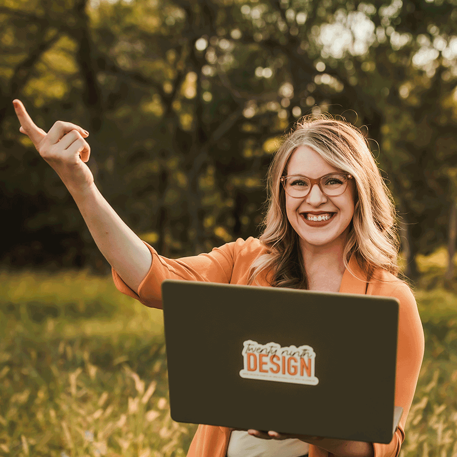  Gif of Hayley Royle, owner of 29th Design, standing in a green Nebraska field while pointing to her laptop that she is holding.